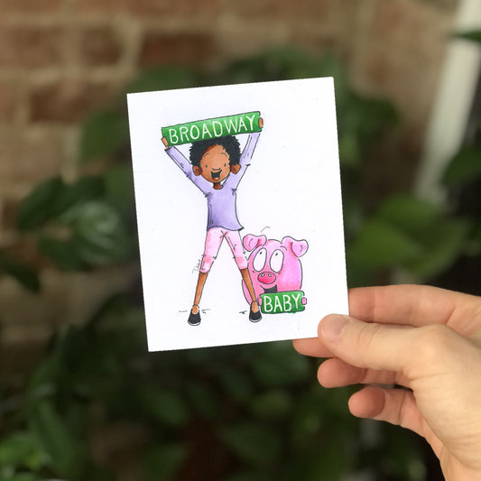 The 'Broadway Baby' greeting card held by my hand. A perfect theater gift for theater lovers.